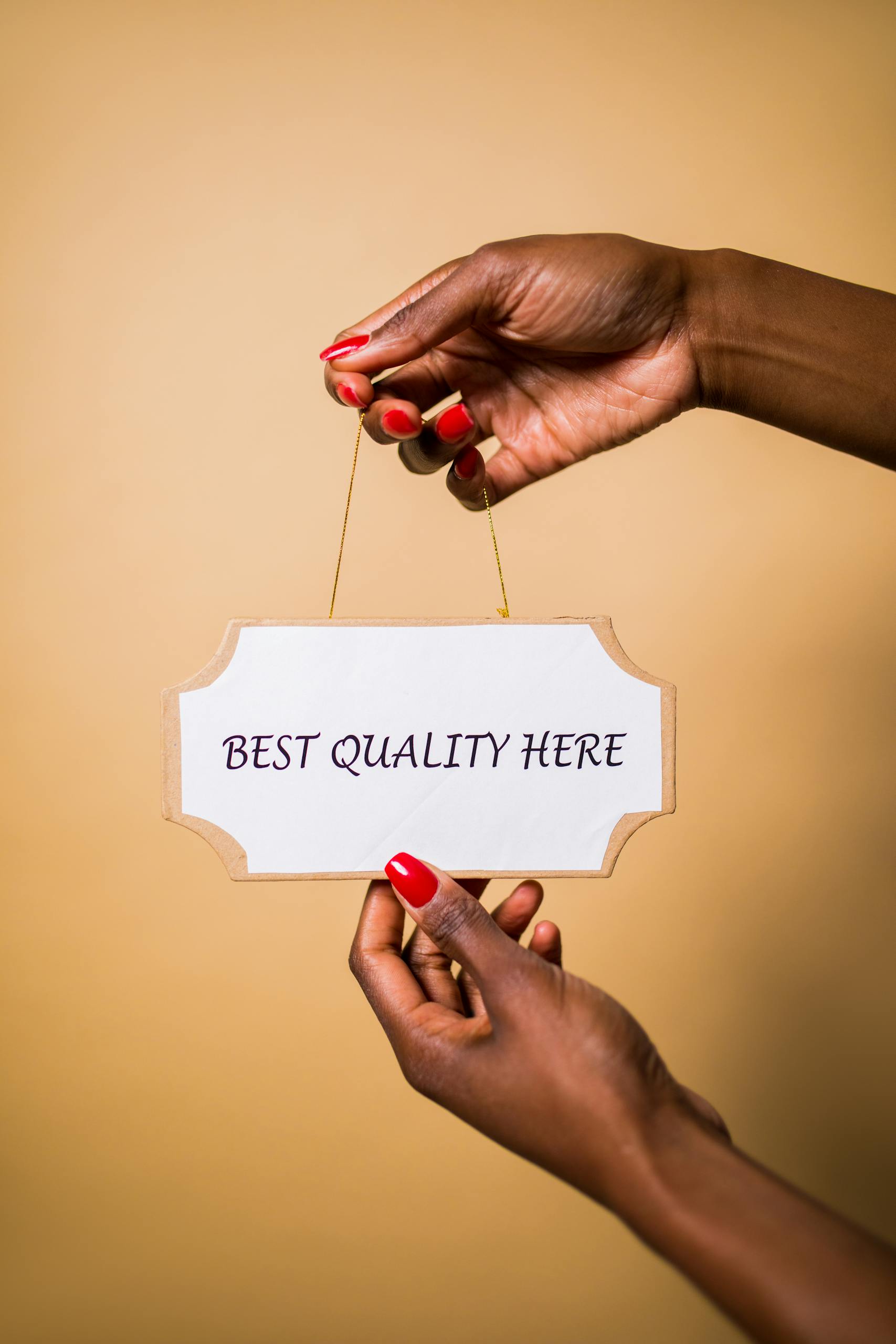 Person Holding a Board with a Text Saying "Best Quality Here"